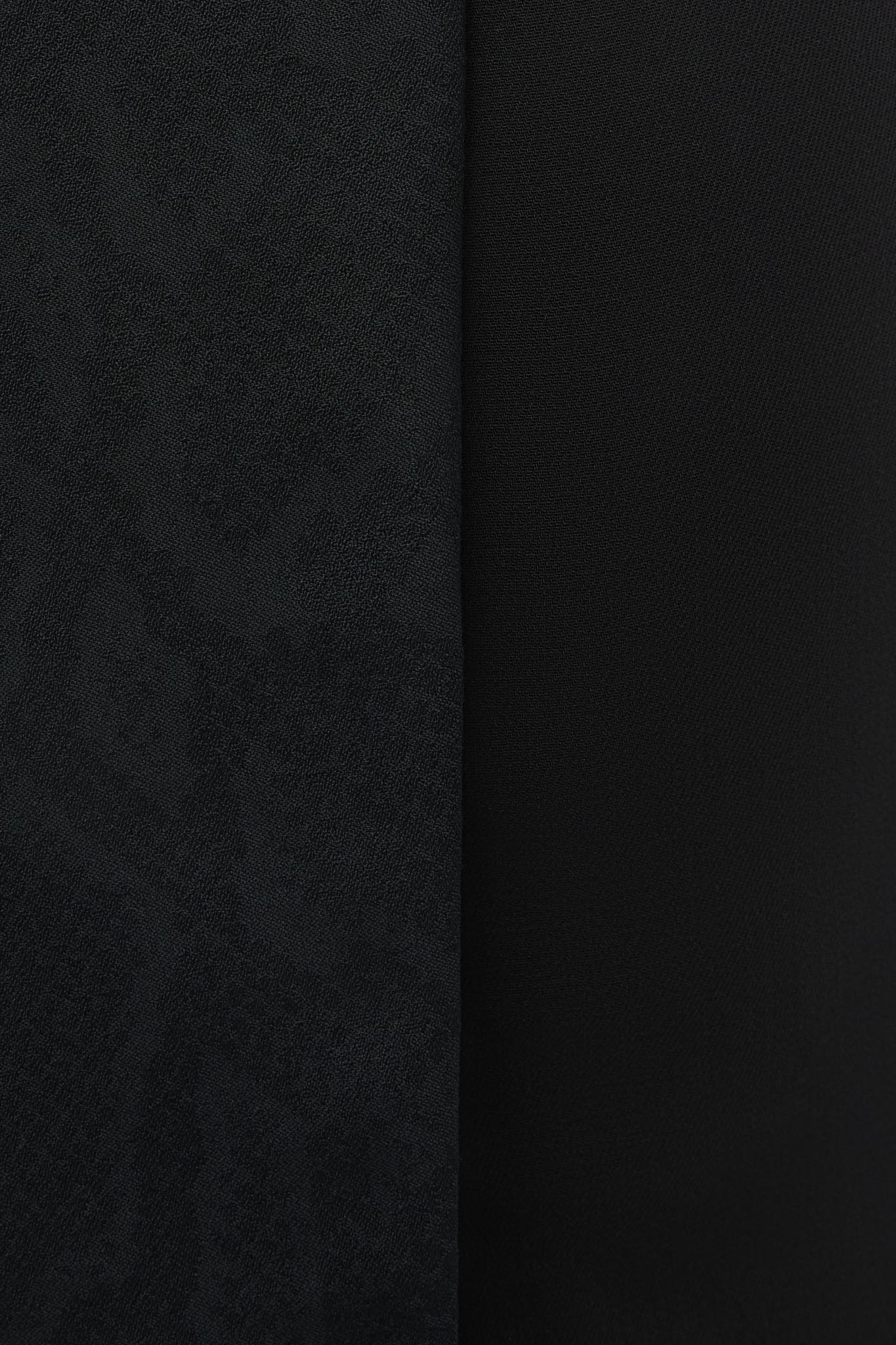 A close-up of a dark fabric material with a subtle textured pattern on the left side and a smooth matte finish on the right side, divided by a vertical seam.